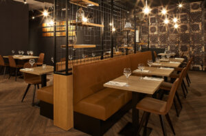 Restaurant La Maison Des Grillades in Doornik met een warme sfeer, gekenmerkt door houten accenten en sfeerverlichting.