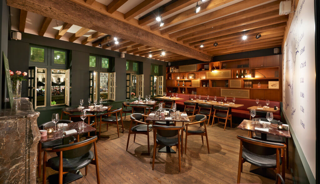Eetruimte met een warme en uitnodigende sfeer, gekenmerkt door houten details en olijfgroene muren in Midtown Grill
